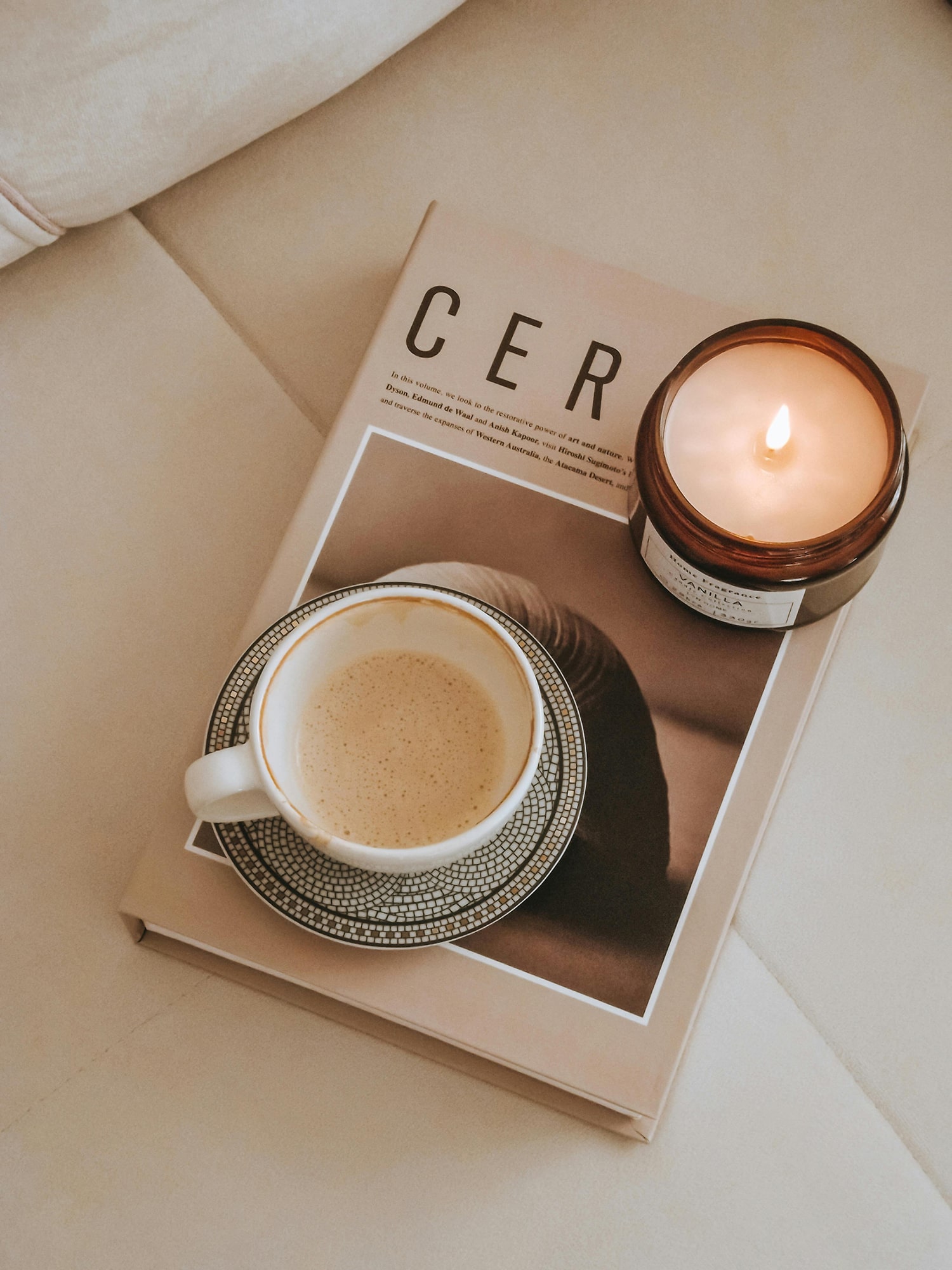 Coffee and candle arranged on a neutral coffee table