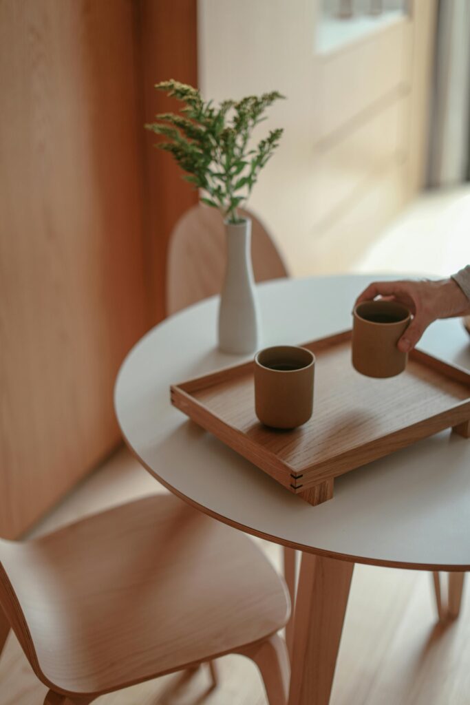 Cozy dining table with coffee and greenery in a warm, sunlit home.